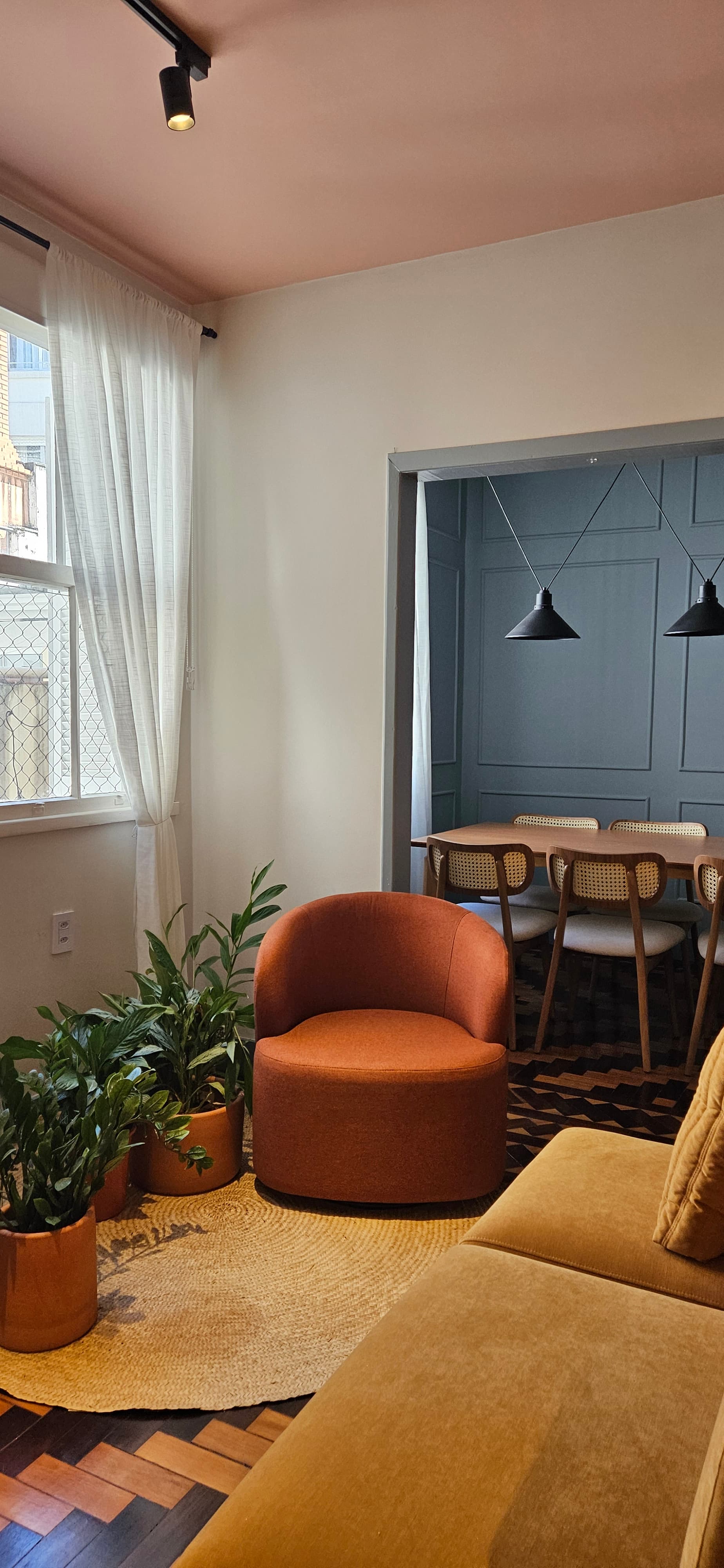 interior com cadeira terracota, plantas e atmosfera acolhedora